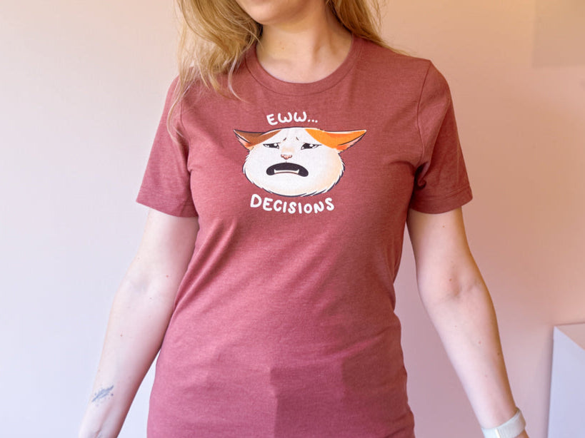 Woman wearing a red t-shirt with a graphic design of a cat that's looking particularly upset with the text "eww.. decisions" on it.